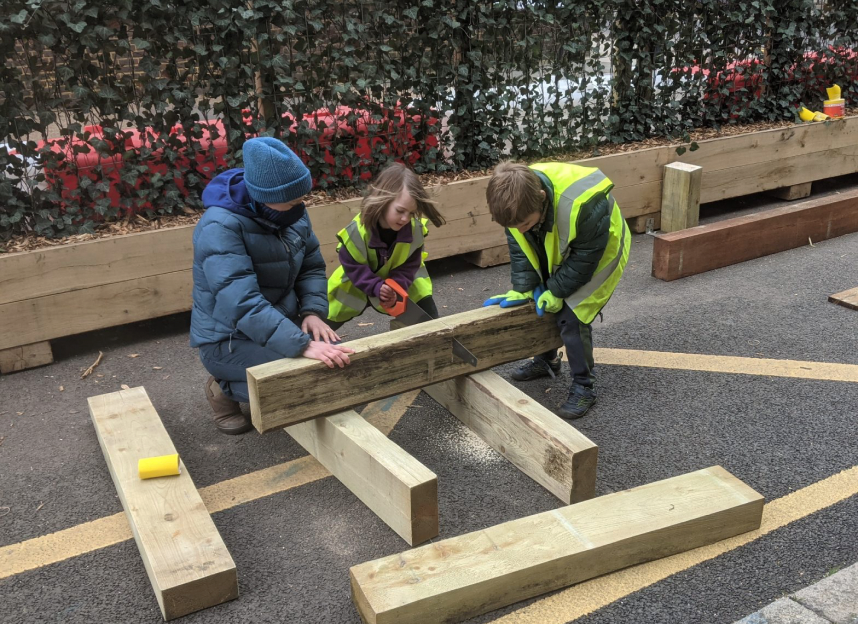Workshop participants cutting timber together
