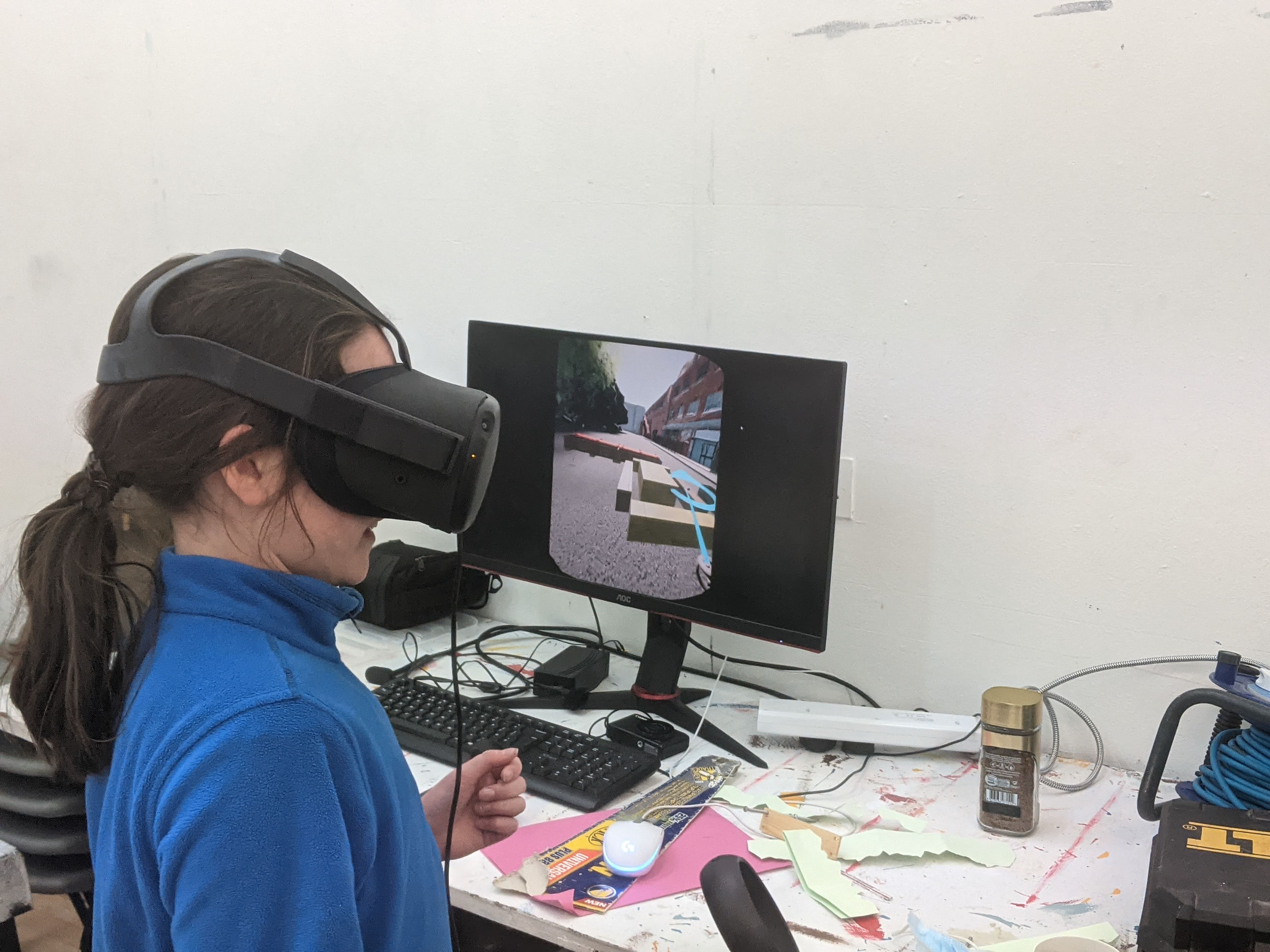 Workshop participant testing the street design in VR, with virtual blocks visible on the monitor